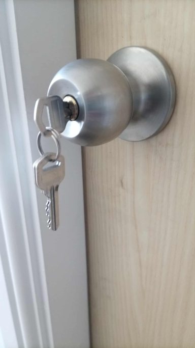 Silver door knob with a key inserted.